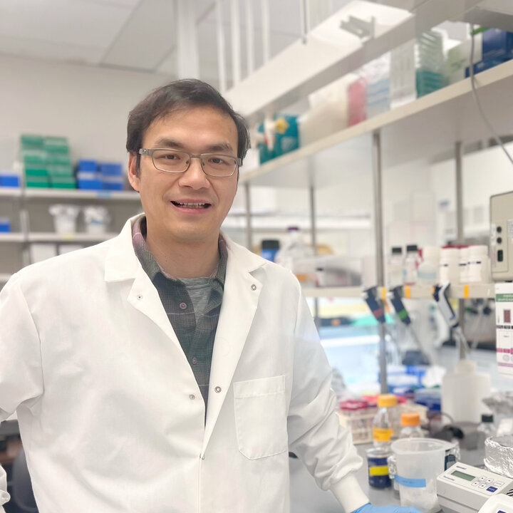 Huang Li, research assistant professor of biochemistry and Heuermann Research Fellow at the University of Nebraska–Lincoln, poses in a lab, wearing a labcoat.