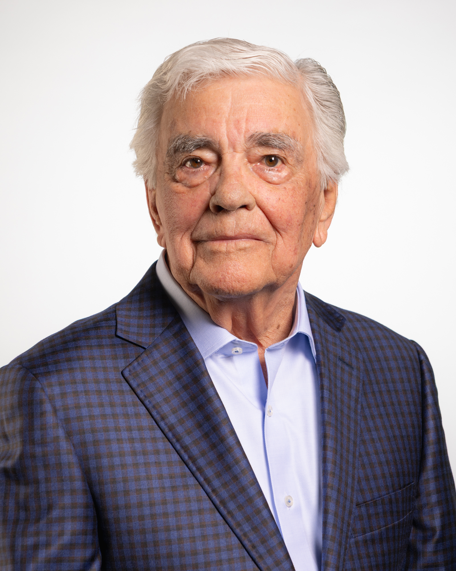 Color portrait of Richard L. Youngscap, architect and golf course founder/developer. He is wearing a blue-and-black plaid sport coat over a light blue dress shirt.