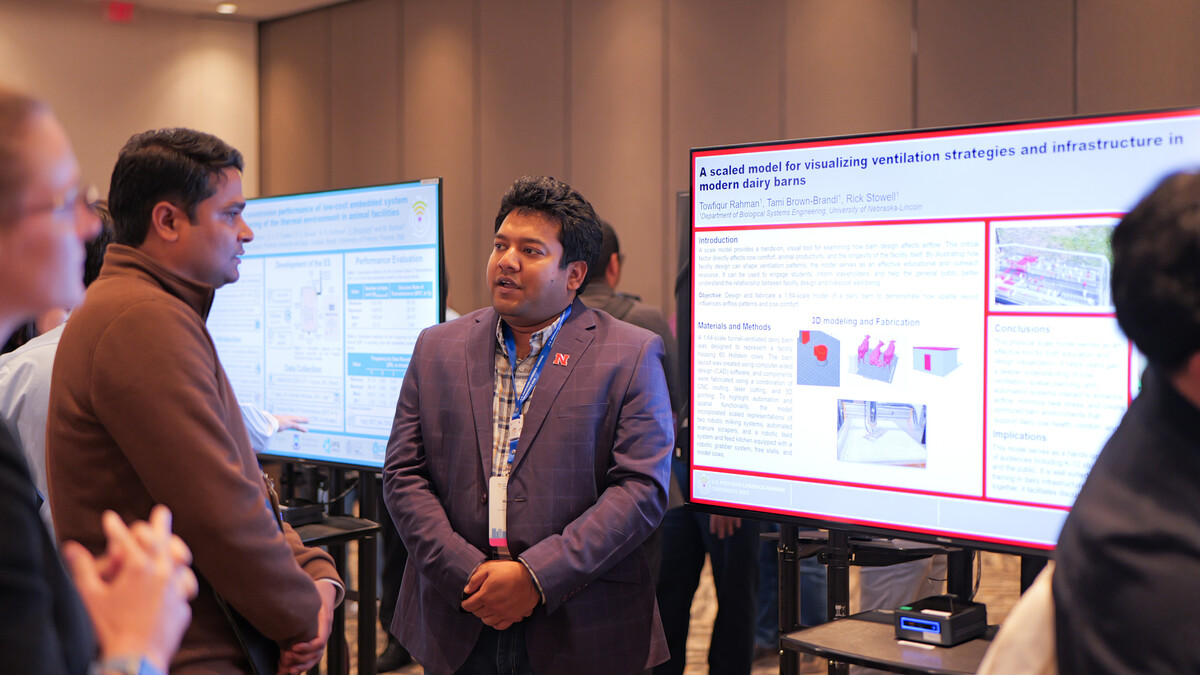 Towfiqur Rahman (right), Ph.D., biological engineering, presents his research on visualizing ventilation and infrastructure in modern dairy barns to USPLF conference attendees during the digital poster session.