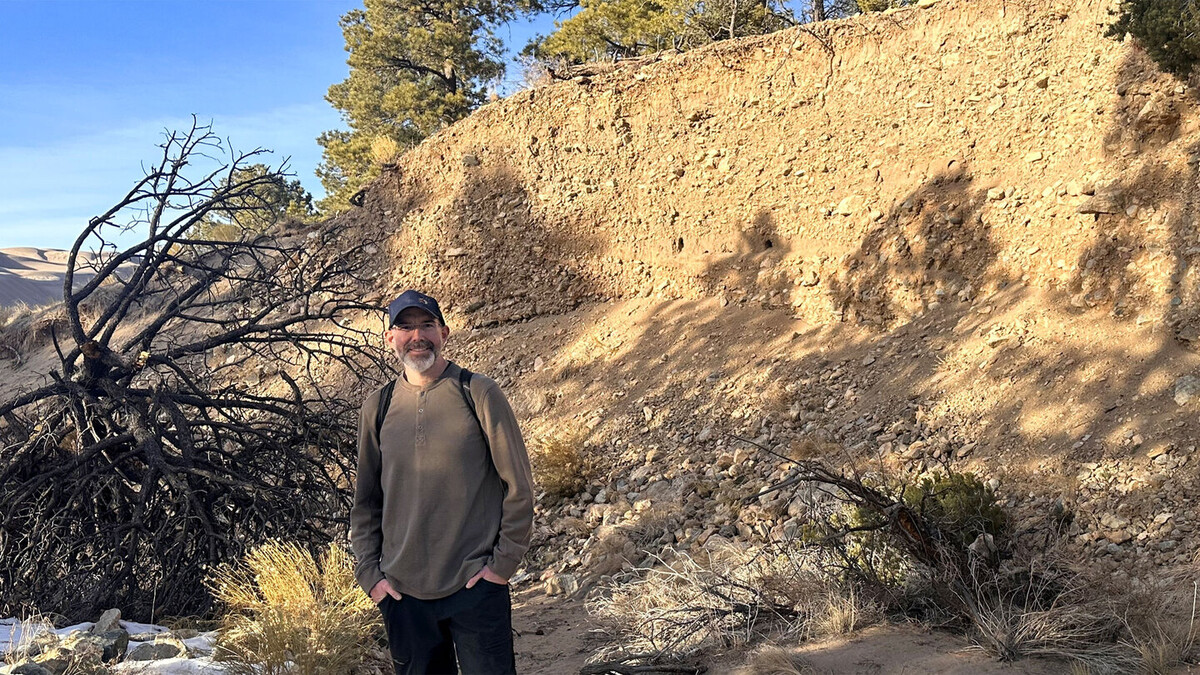 Aaron Lee M. Daigh stands near a soil profile in January 2026 at Great Sand Dunes National Park in Colorado.