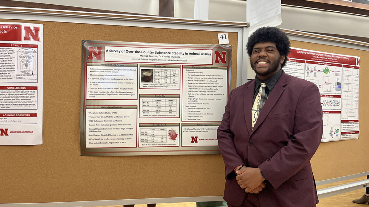 Marcus Cureton presents his research during a poster session.