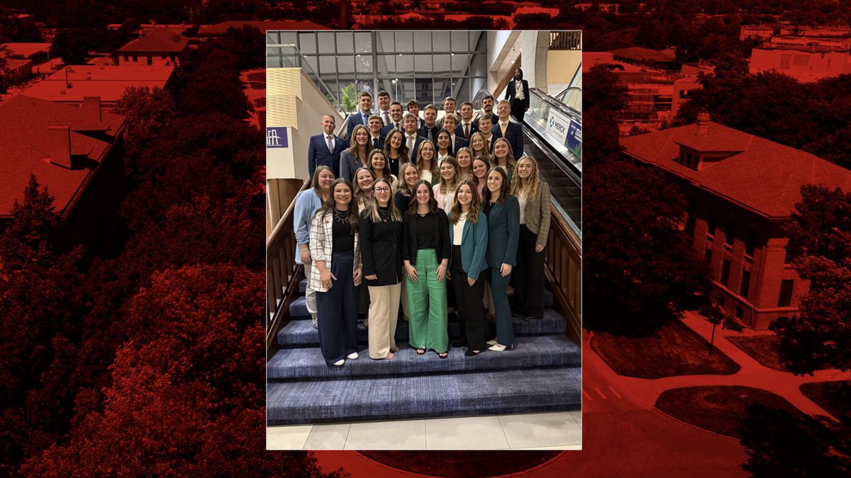 A group of 37 University of Nebraska–Lincoln CASNR students pose together on a staircase at the 2025 AFA Leaders Conference. The students, dressed in professional business attire, stand in several rows and smile toward the camera inside a large conference venue with glass windows and escalators in the background.