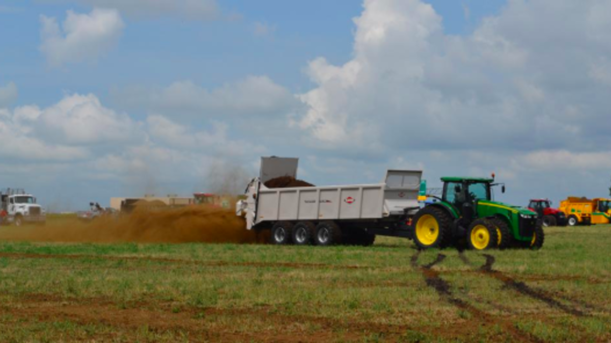 A tractor dumping manure.