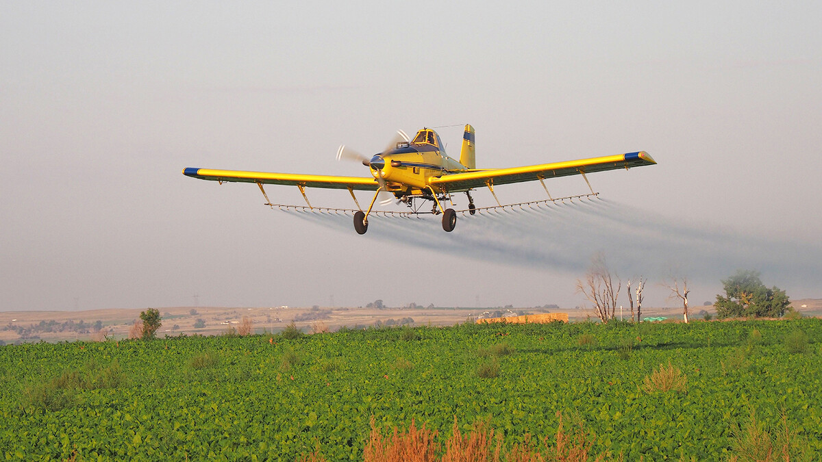 Plane makes an ariel application on field