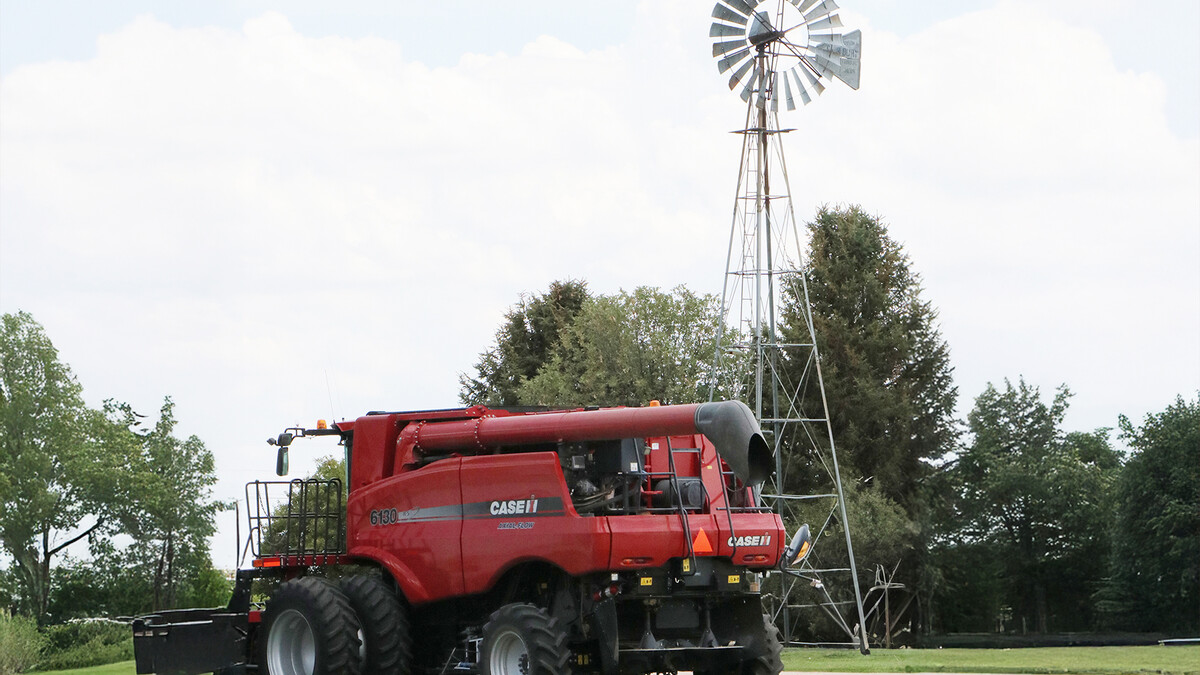 farm equipment in front of windmill