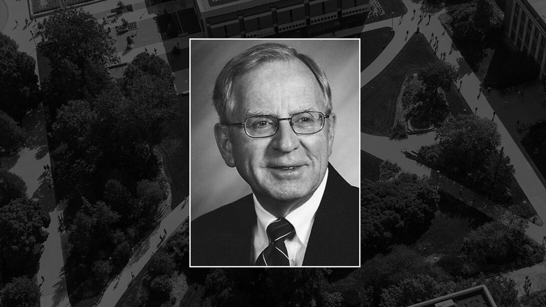 A black-and-white photo of Duane Acker, former vice chancellor of the Institute of Agriculture and Natural Resources, on a black campus background.