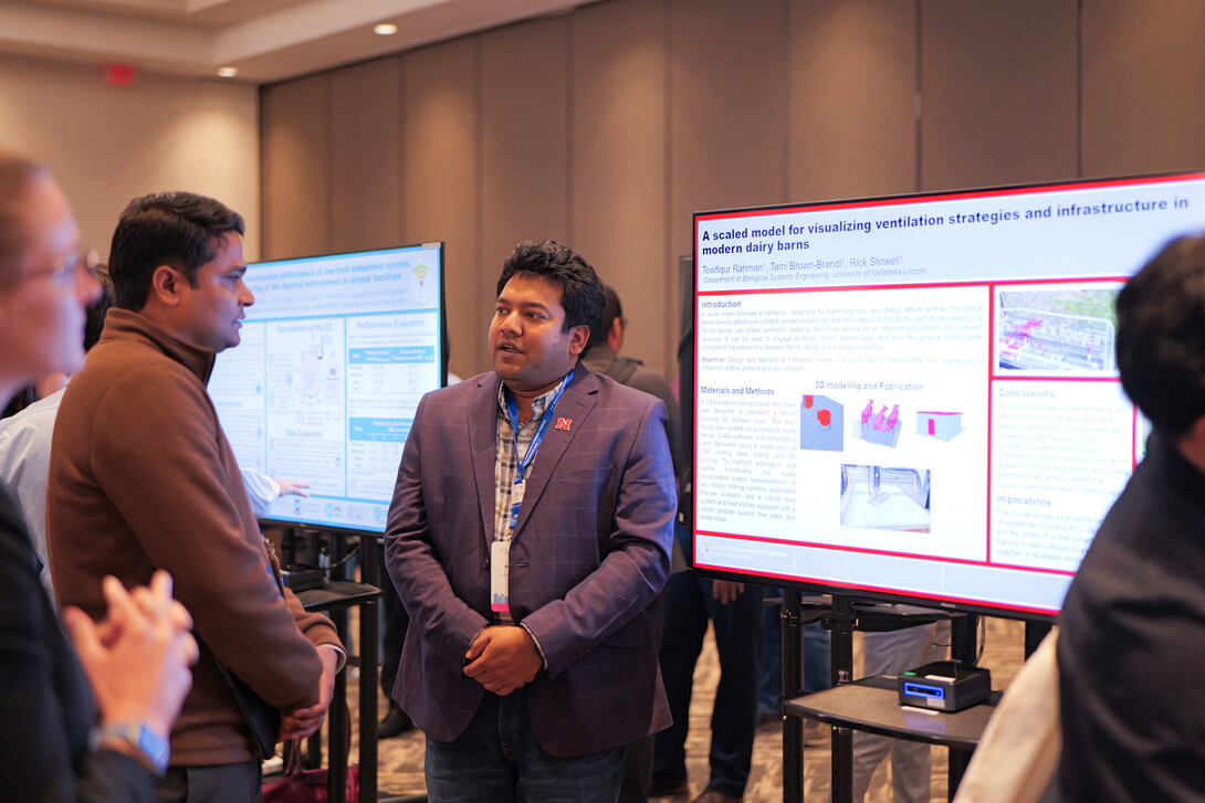 Towfiqur Rahman (right), Ph.D., biological engineering, presents his research on visualizing ventilation and infrastructure in modern dairy barns to USPLF conference attendees during the digital poster session.