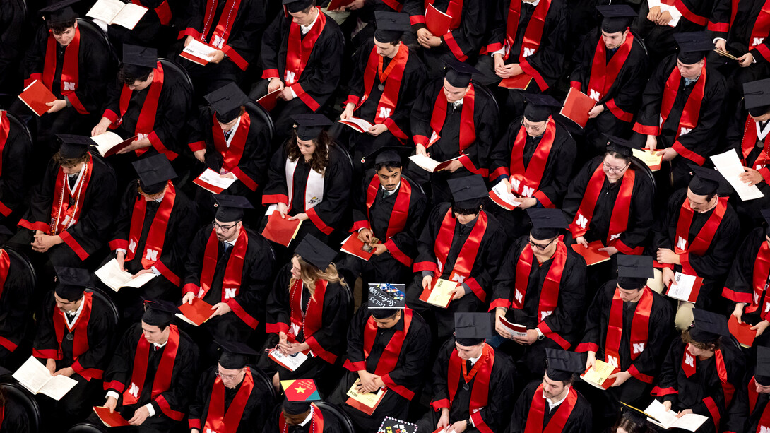 Husker graduates are seen with their diplomas in their seats at Pinnacle Bank Arena.