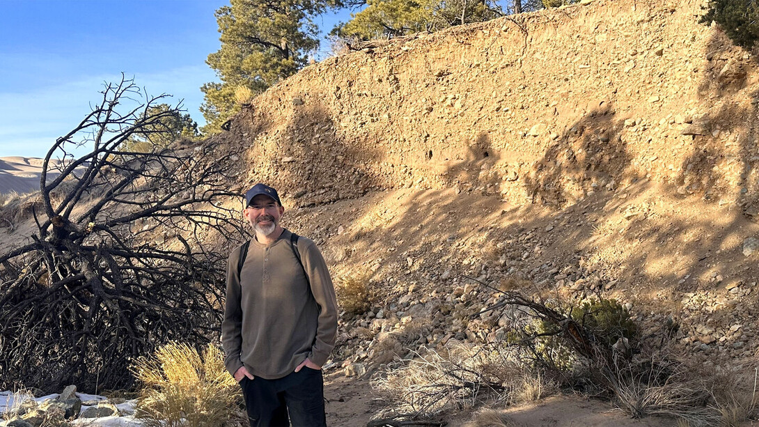 Aaron Lee M. Daigh stands near a soil profile in January 2026 at Great Sand Dunes National Park in Colorado.