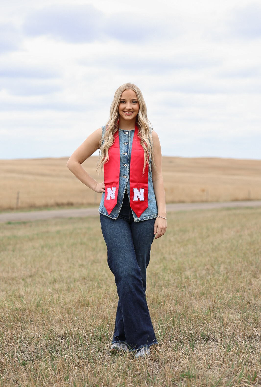 Annalee Starr stands in a pasture, holding a magazine featuring her writing