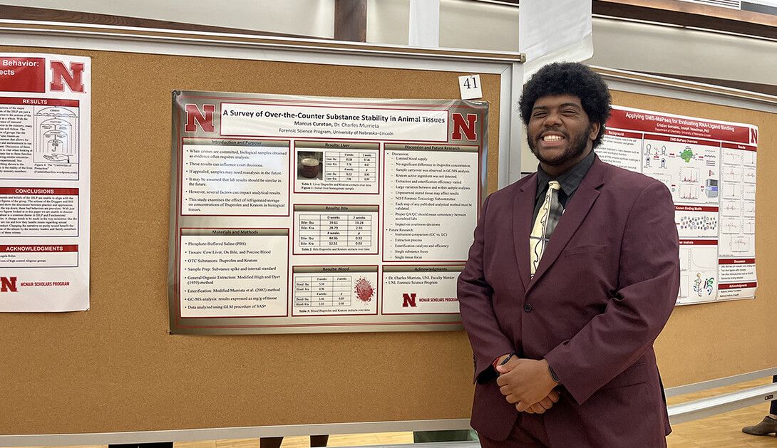 Marcus Cureton presents his research during a poster session.