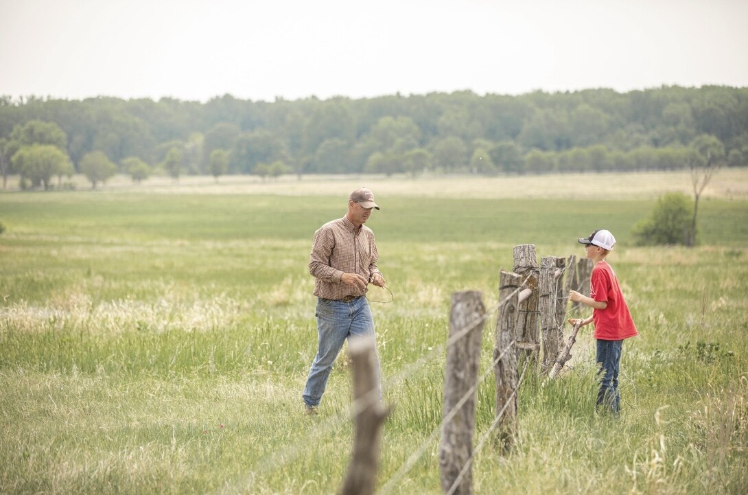 Troy Anderson and son working on fence