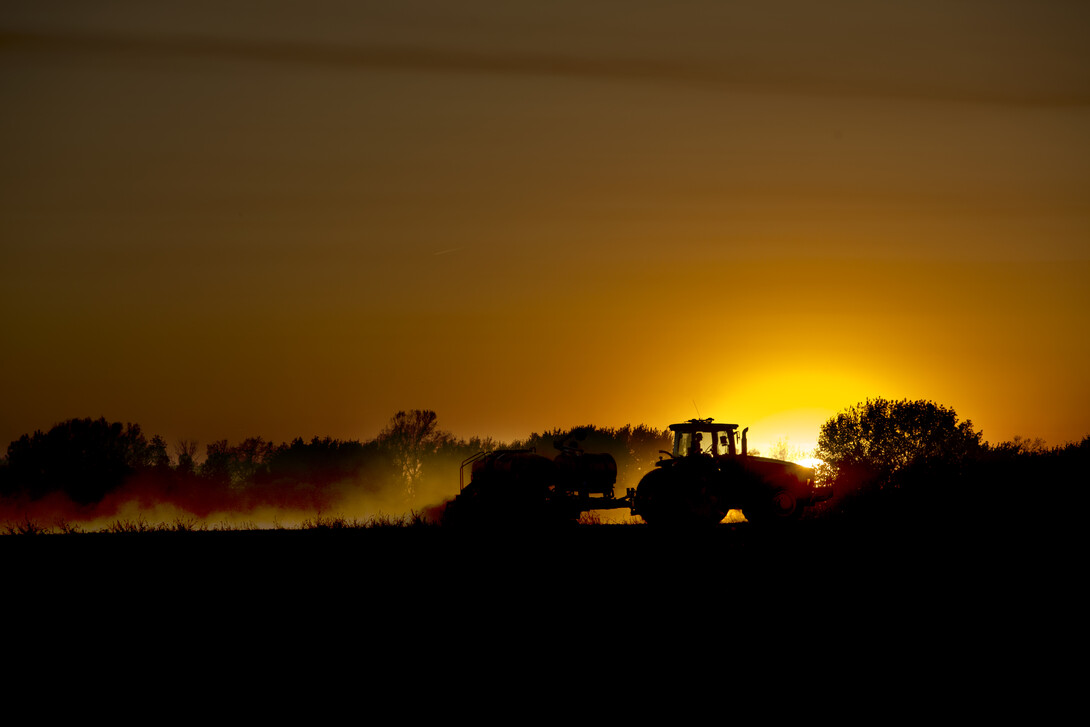 tractor planting in sunset