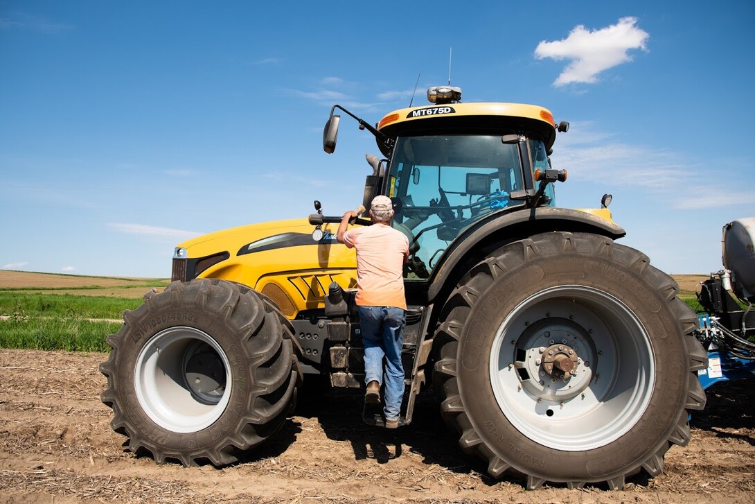 Farmer getting into tractor