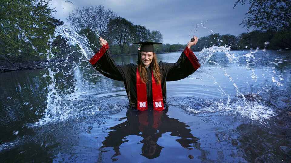 Vondracek in cap and gown in a lake