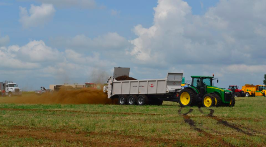 A tractor dumping manure.