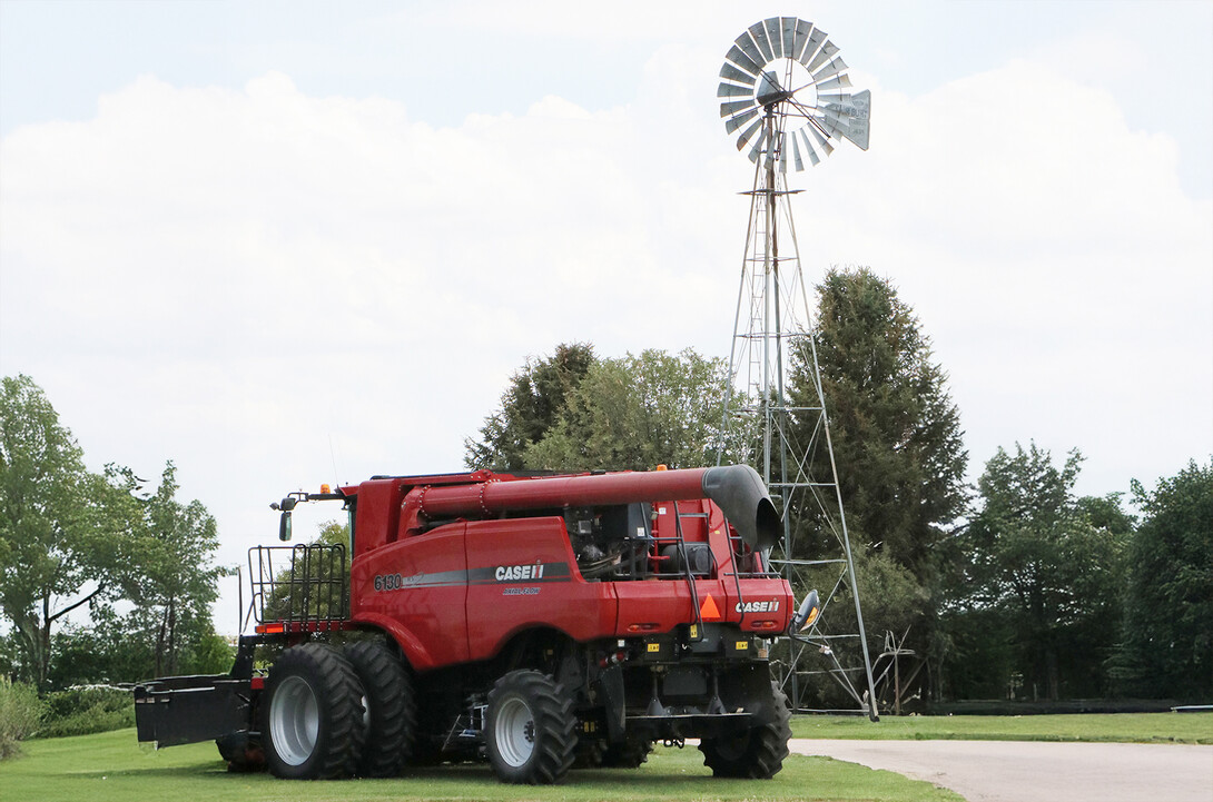 farm equipment in front of windmill