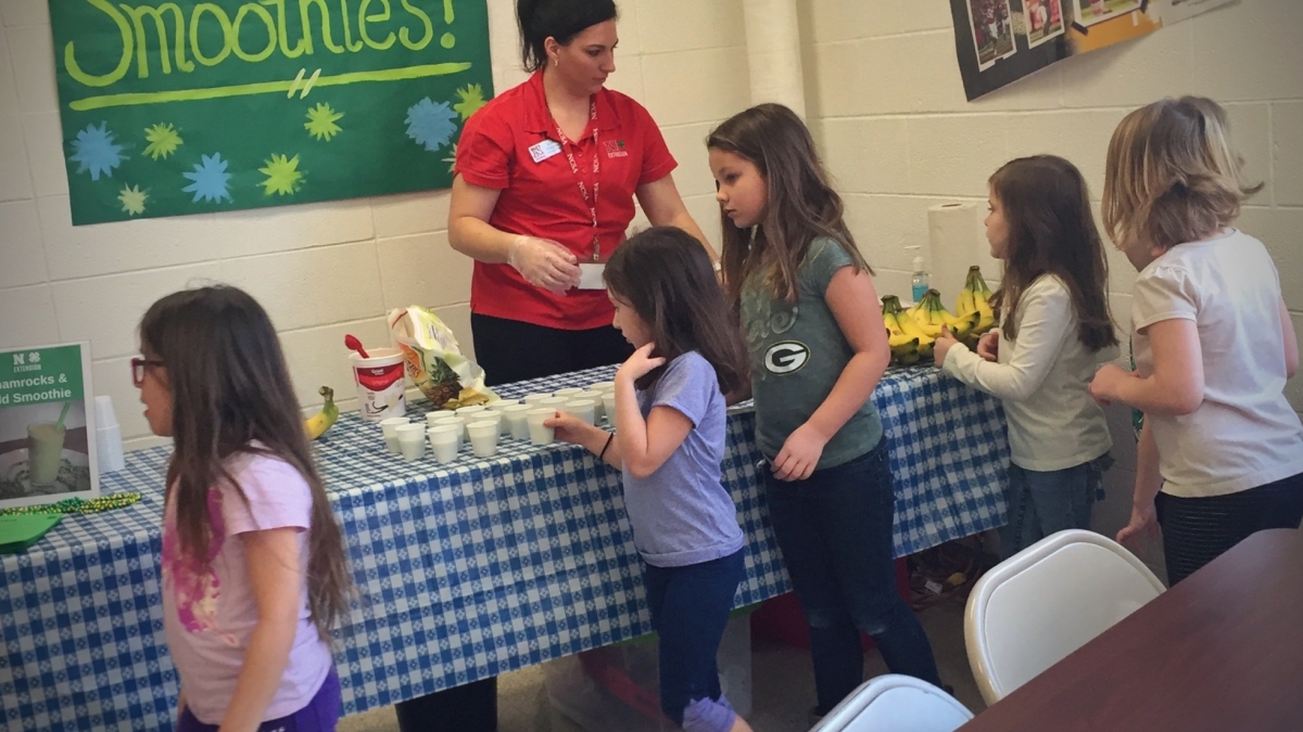 Nebraska Extension Educator Kayla Colgrove shares smoothie samples with Tri County Public Schools students during a recent farmers market held at the school.