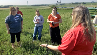 Several teachers stand in a field near the Haskell Agricultural Laboratory.