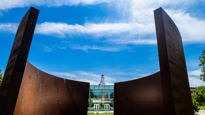 The Love Library cupola and Adele Coryell Hall Learning Commons are framed by the Greenpoint sculpture.