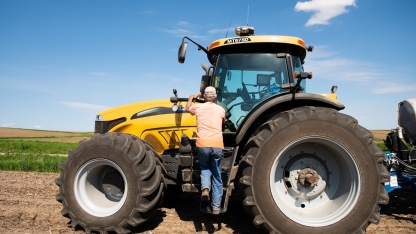 Farmer getting into tractor