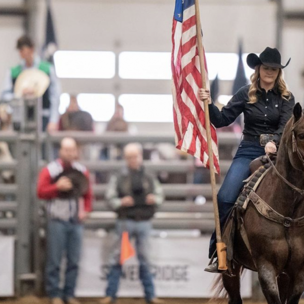 Contestant holds flag in rodeo arena